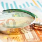 magnifying glass on top of euro notes