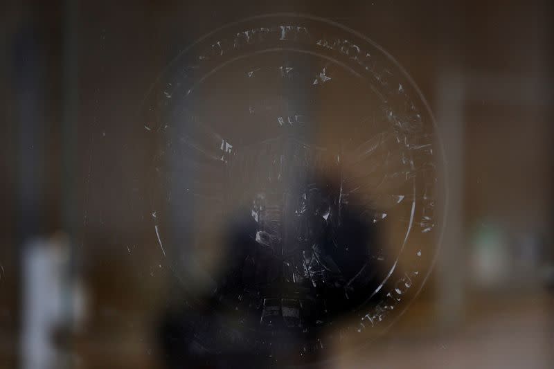 FILE PHOTO: The name and logo for the Consumer Financial Protection Bureau (CPFB) is seen scraped off the door of its building in Washington, D.C., U.S., February 20, 2025. REUTERS/Brian Snyder/