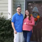 a couple standing by their front door